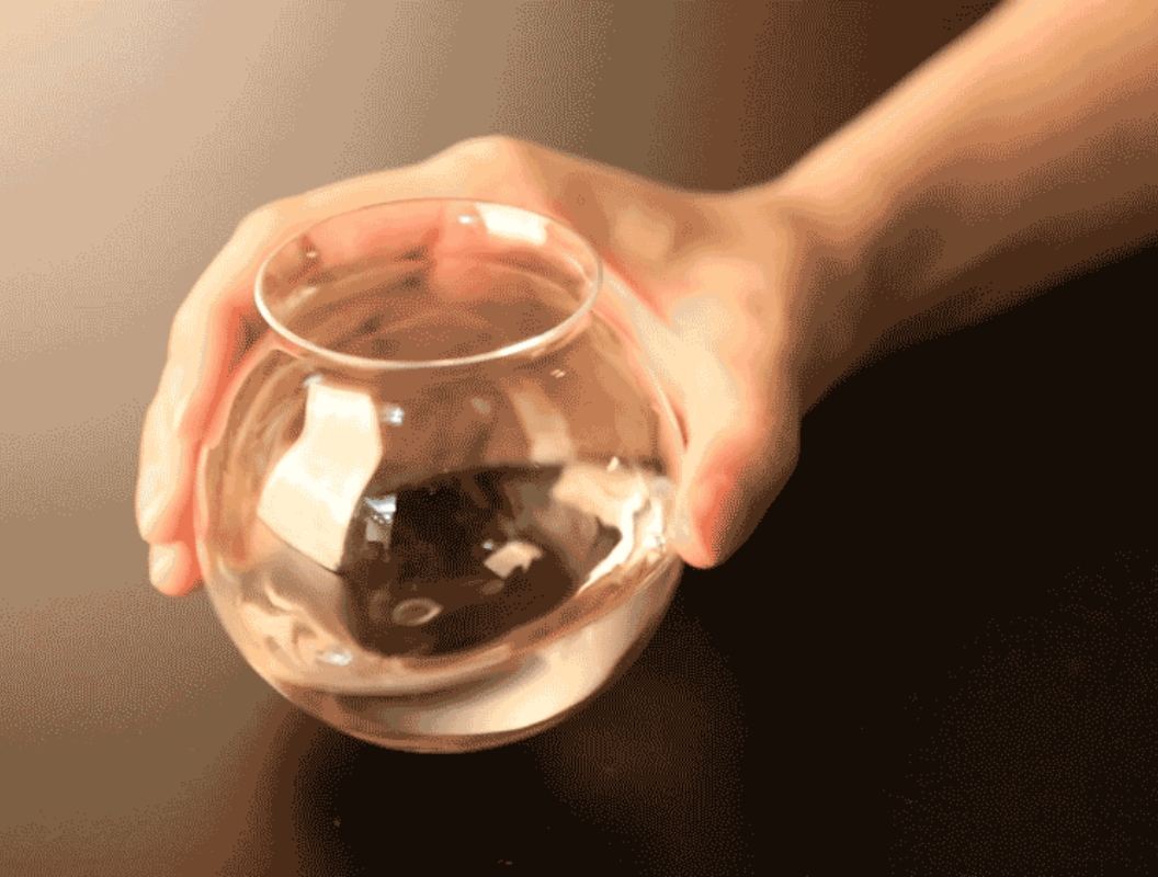 日本酒が注がれたグラスを握りこむ写真